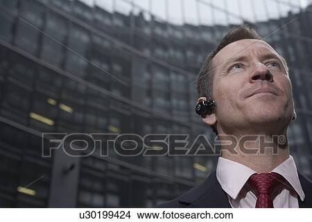 Businessman wearing headset outdoors View Large Photo Image Picture - Businessman wearing headset outdoors. Fotosearch