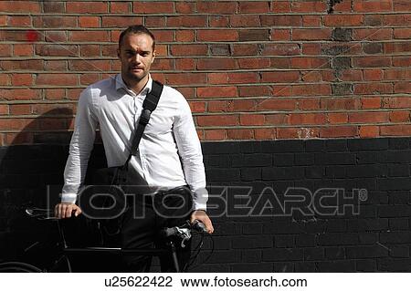 Businessman with bicycle on city street View Large Photo Image Stock Image - Businessman with bicycle on city street. Fotosearch