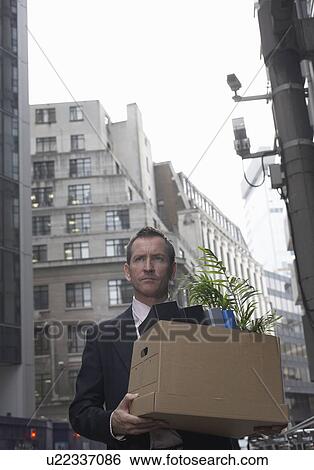 Businessman with box of office supplies View Large Photo Image Stock Photograph - Businessman with box of office supplies. Fotosearch