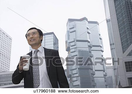 Businessman with coffee on city street View Large Photo Image Stock Photo - Businessman with coffee on city street. Fotosearch