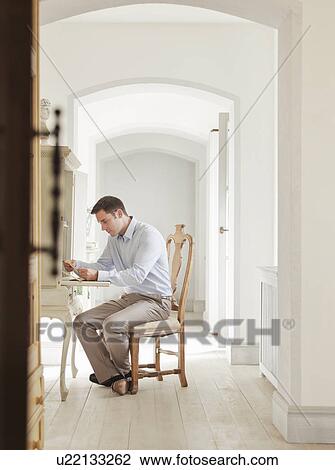 Stock Image - Businessman working at home office. Fotosearch
