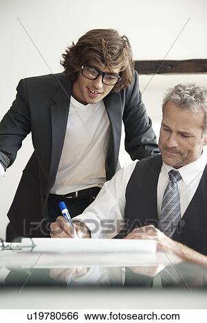 Businessmen working together in office View Large Photo Image Stock Photograph - Businessmen working together in office. Fotosearch