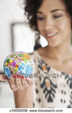 Businesswoman holding miniature globe View Large Photo Image Stock Photo - Businesswoman holding miniature globe. Fotosearch