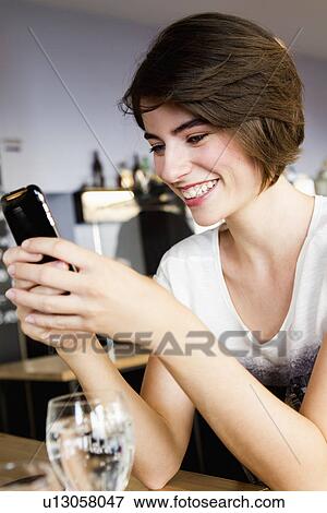 Businesswoman using cell phone in cafe View Large Photo Image Stock Photo - Businesswoman using cell phone in cafe. Fotosearch