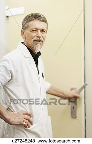 Stock Photo - Butcher opening meat closet door. Fotosearch