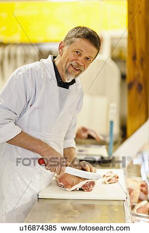 Butcher slicing meat at counter View Large Photo Image Stock Photography - Butcher slicing meat at counter. Fotosearch