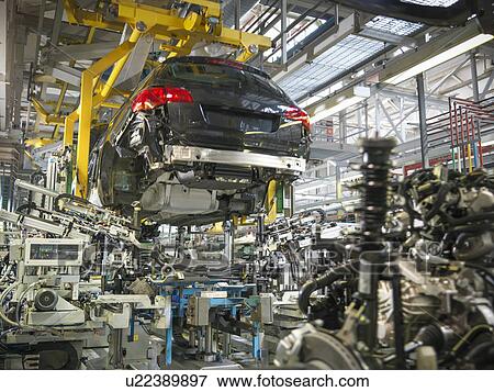 Stock Photo - Car body and engine transmission marriage in car factory. Fotosearch