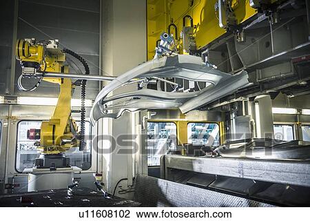 Stock Image - Car parts handled by robots in car factory. Fotosearch