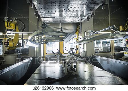 Stock Photograph - Car parts handled by robots in car factory. Fotosearch
