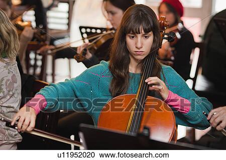 Stock Image - Cello player practicing with group. Fotosearch