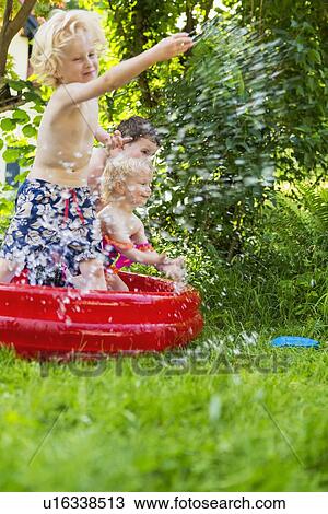 Children splashing in paddling pool View Large Photo Image Stock Image - Children splashing in paddling pool. Fotosearch