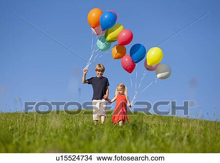 Picture - Children with colorful balloons in grass. Fotosearch