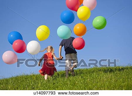 Children with colorful balloons in grass View Large Photo Image Stock Image - Children with colorful balloons in grass. Fotosearch