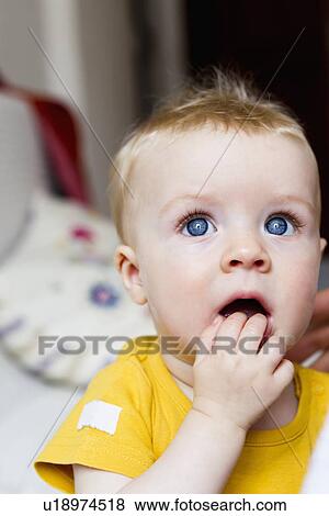 Stock Photo - Close up of baby chewing fingers. Fotosearch