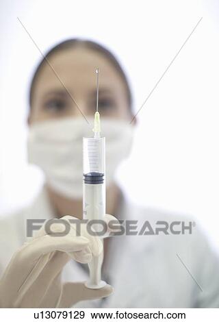 Stock Photo - Close up of doctor preparing syringe. Fotosearch