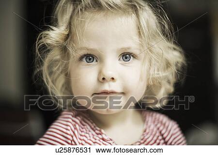 Stock Image - Close up of girls curious face. Fotosearch