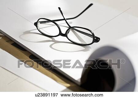 Stock Photo - Close up of glasses on pad of paper. Fotosearch