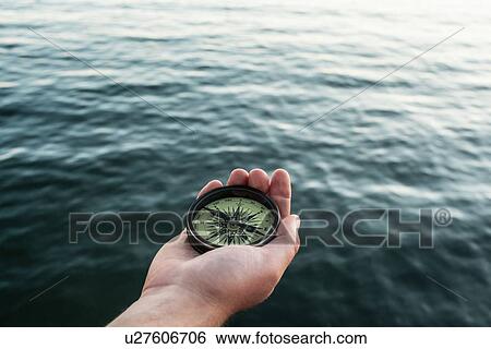 Close up of hand holding compass View Large Photo Image Stock Photograph - Close up of hand holding compass. Fotosearch