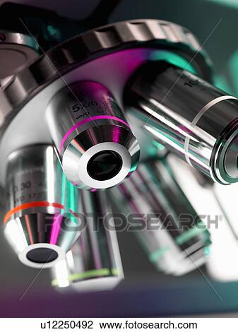 Stock Image - Close up of microscope lenses in lab. Fotosearch