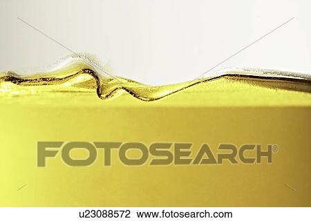 Stock Image - Close up of oil in glass. Fotosearch