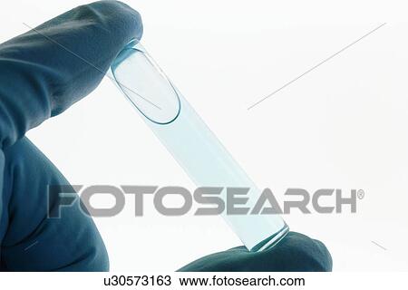 Stock Image - Close up of scientist holding test tube. Fotosearch