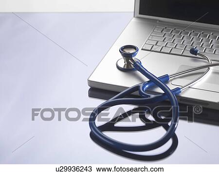 Stock Image - Close up of stethoscope on laptop. Fotosearch