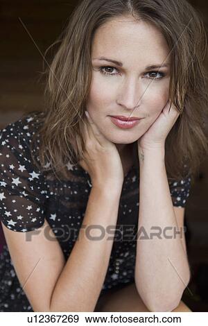 Close up of woman resting chin in hands View Large Photo Image Stock Photo - Close up of woman resting chin in hands. Fotosearch