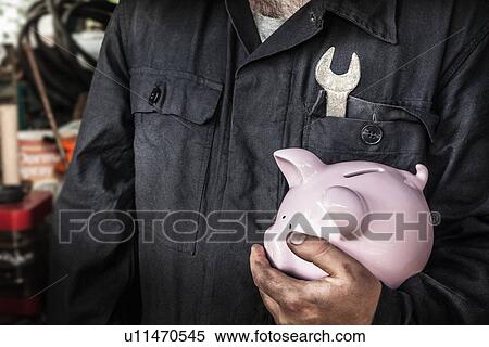 Close up of worker holding piggy bank View Large Photo Image Stock Photography - Close up of worker holding piggy bank. Fotosearch