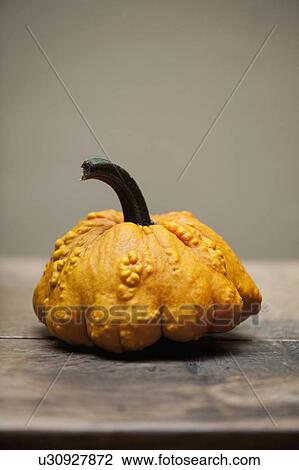 Stock Image - Close up of yellow gourd on table. Fotosearch