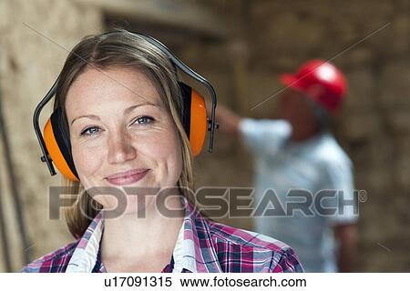 Stock Photography - Construction worker wearing headphones. Fotosearch