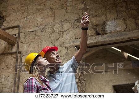Stock Photo - Construction workers examining stone. Fotosearch