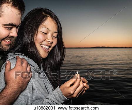 Stock Image - Couple admiring ring outdoors. Fotosearch