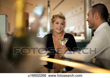 Couple having drinks at bar View Large Photo Image Stock Photograph - Couple having drinks at bar. Fotosearch