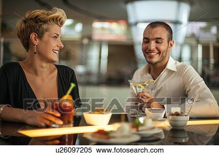 Stock Photography - Couple having drinks at bar. Fotosearch