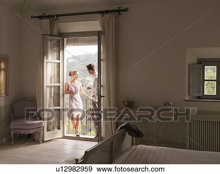 Couple having wine on balcony View Large Photo Image Stock Photo - Couple having wine on balcony. Fotosearch