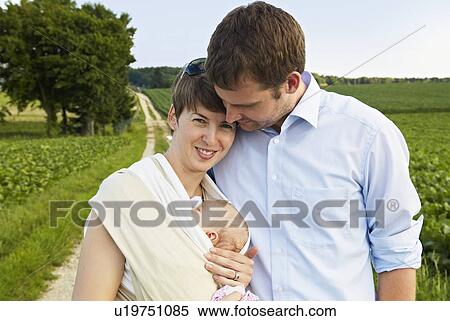 Couple holding infant on rural road View Large Photo Image Stock Photography - Couple holding infant on rural road. Fotosearch