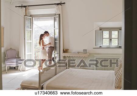 Stock Image - Couple hugging on balcony. Fotosearch