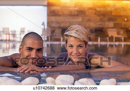 Couple relaxing in modern indoor pool View Large Photo Image Stock Photo - Couple relaxing in modern indoor pool. Fotosearch
