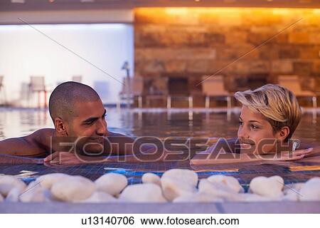 Couple relaxing in modern indoor pool View Large Photo Image Stock Photograph - Couple relaxing in modern indoor pool. Fotosearch