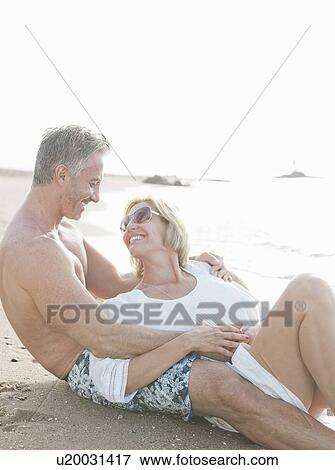 Stock Photo - Couple relaxing together on beach. Fotosearch