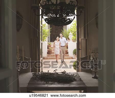Stock Image - Couple walking in courtyard. Fotosearch