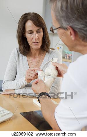 Doctor showing patient model of bones View Large Photo Image Stock Image - Doctor showing patient model of bones. Fotosearch