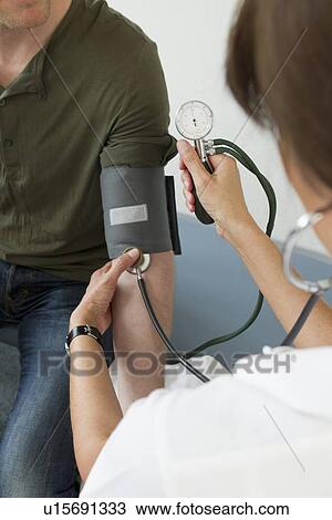 Doctor taking patients blood pressure View Large Photo Image Stock Image - Doctor taking patients blood pressure. Fotosearch