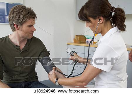 Doctor taking patients blood pressure View Large Photo Image Stock Photograph - Doctor taking patients blood pressure. Fotosearch