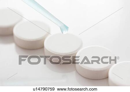 Dropper placing liquid on pills View Large Photo Image Stock Photo - Dropper placing liquid on pills. Fotosearch