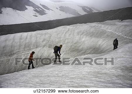 Family hiking on snowy hillside View Large Photo Image Stock Photo - Family hiking on snowy hillside. Fotosearch