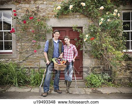 Stock Photo - Farmer and wife holding vegetables. Fotosearch