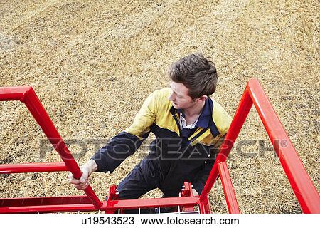 Farmer climbing machinery ladder View Large Photo Image Stock Image - Farmer climbing machinery ladder. Fotosearch