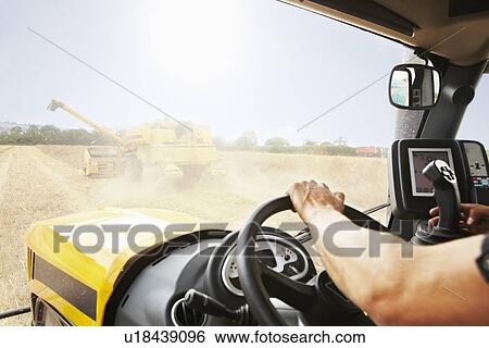 Farmer driving thresher in crop field View Large Photo Image Stock Photograph - Farmer driving thresher in crop field. Fotosearch