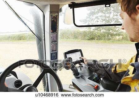 Stock Photograph - Farmer driving tractor in field. Fotosearch